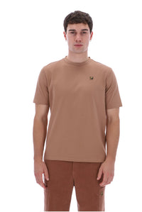 A man wearing a short-sleeve crew-neck t-shirt in a warm tan-brown color, paired with matching brown pants, photographed against a solid white background.