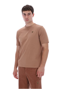 A man wearing a tan short-sleeve crewneck t-shirt and matching brown pants, standing against a plain white background.