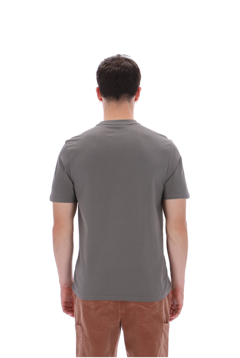 A man viewed from behind wearing a plain gray short-sleeve t-shirt and brown pants, standing against a solid white background.