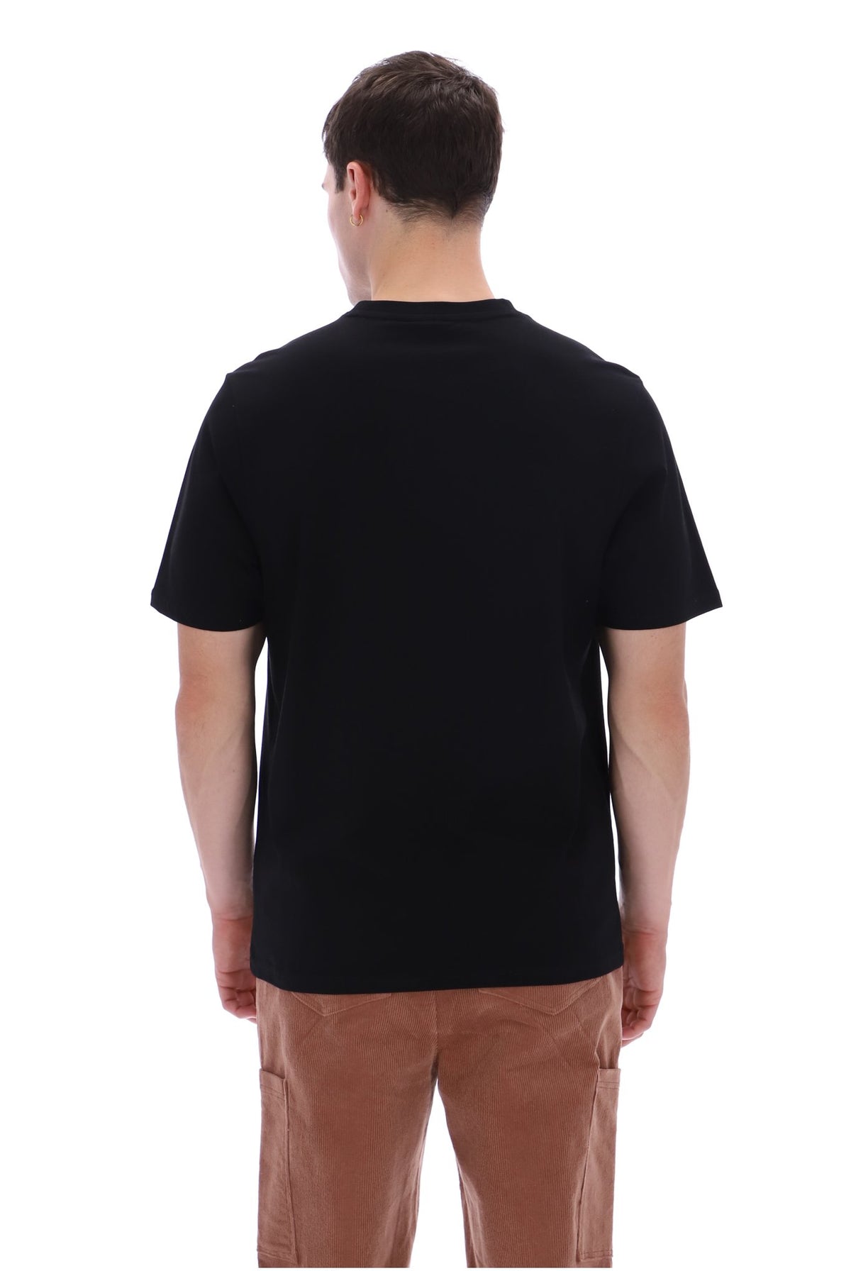 A man viewed from the back wearing a plain black short-sleeve crew-neck t-shirt and brown pants, set against a solid white background.