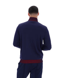 Displays a model wearing the Navy 'FILA' branded Zayn Track Top