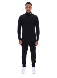 Man wearing a black turtleneck and pants on a white background