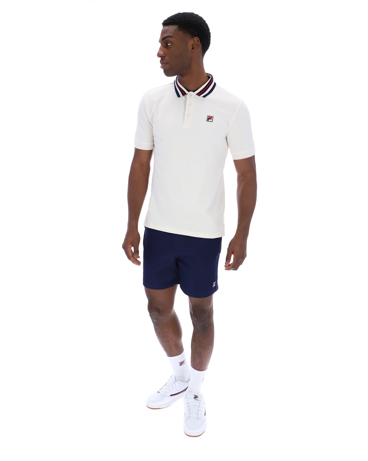 Displays a model wearing the Gardenia 'FILA' branded Achille Heritage Tape Basic Polo