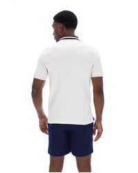 Displays a model wearing the Gardenia 'FILA' branded Achille Heritage Tape Basic Polo
