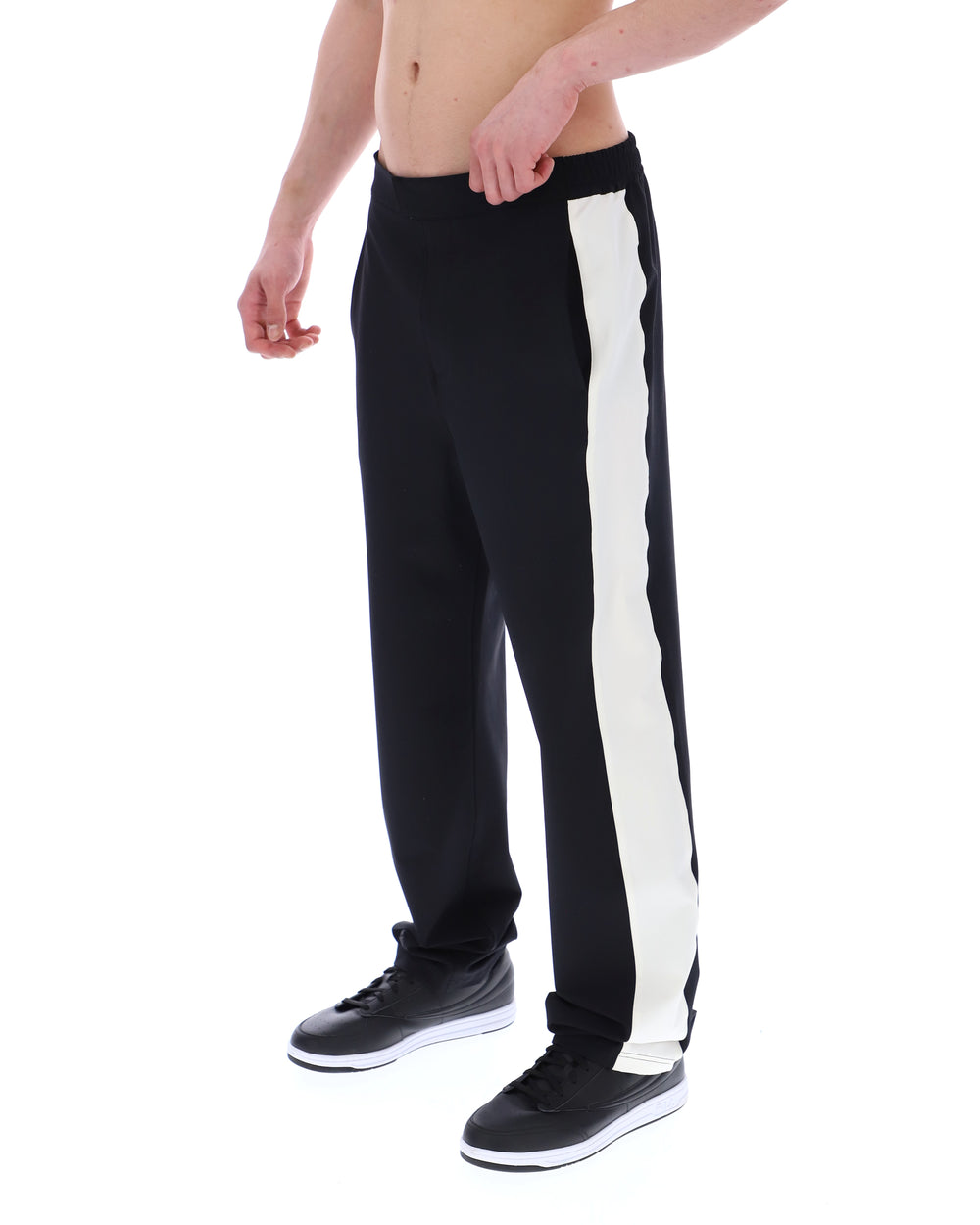 Black track pants with a white stripe on a white background