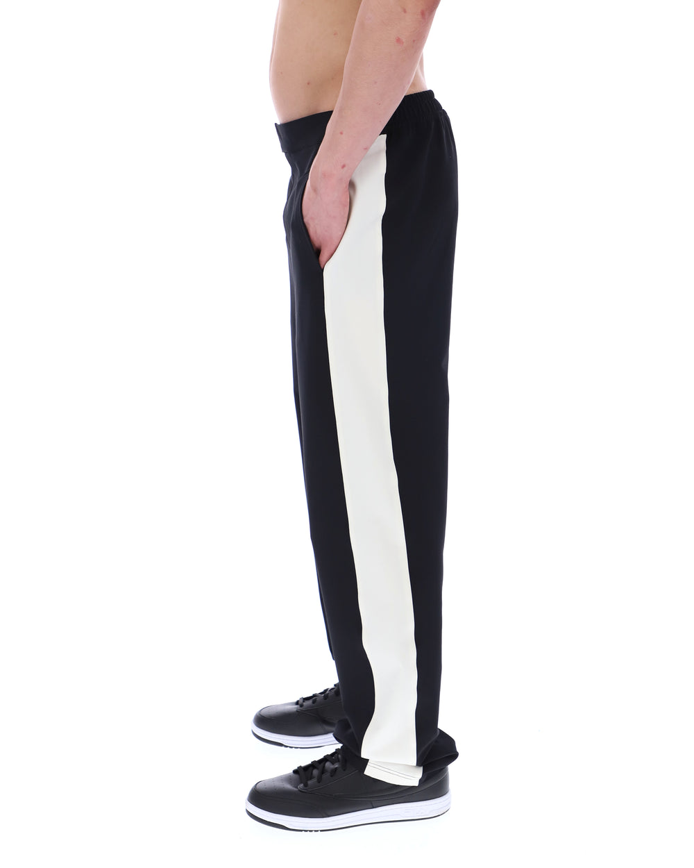Black and white striped pants worn by a person on a white background