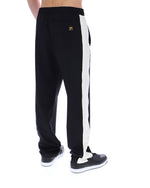 Black track pants with a white stripe on a white background