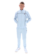 Man wearing a light blue tracksuit with a brand logo on a white background