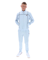 Man wearing a light blue tracksuit with a brand logo on a white background
