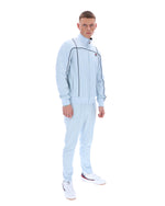 Man wearing a light blue tracksuit with a logo on a white background