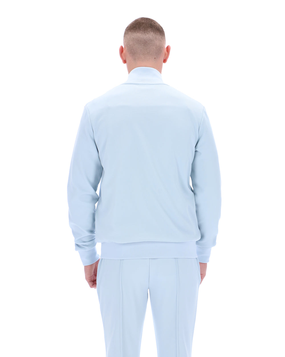 Man wearing a light blue sweater and pants on a white background