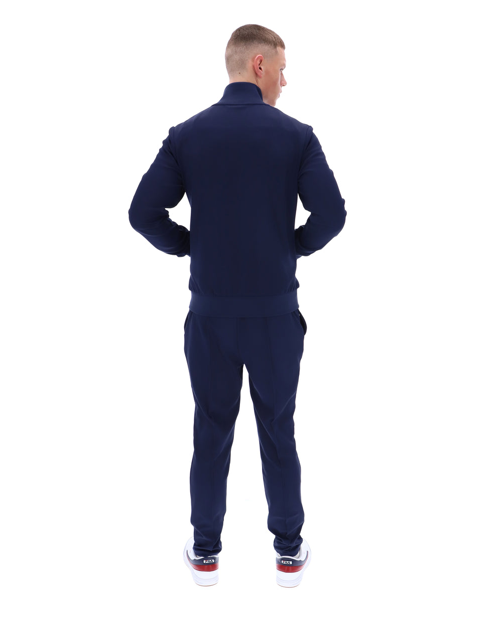 Man wearing a navy tracksuit on a white background