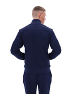 Man wearing a navy blue tracksuit on a white background
