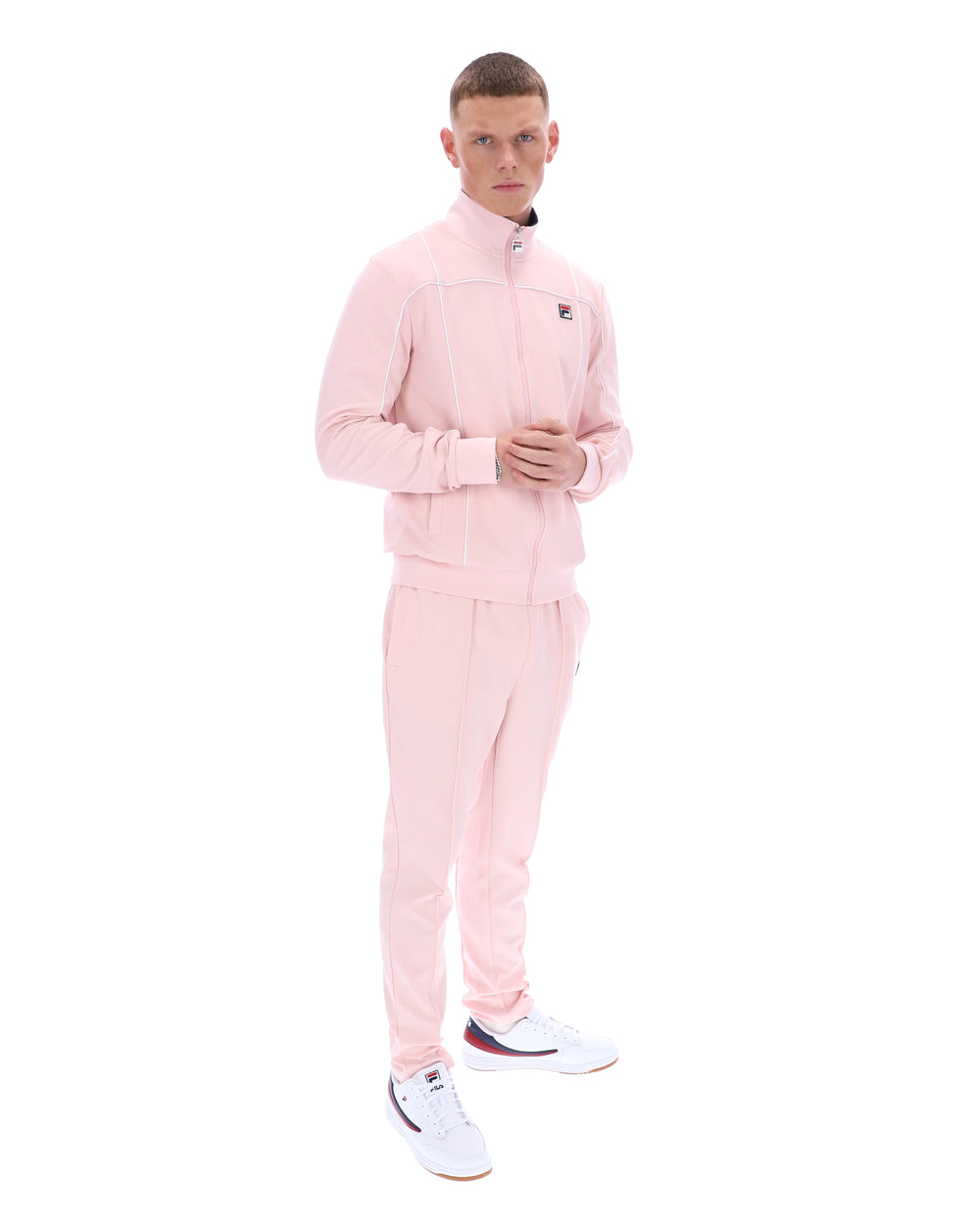 Man wearing a pink tracksuit with a brand logo on a white background