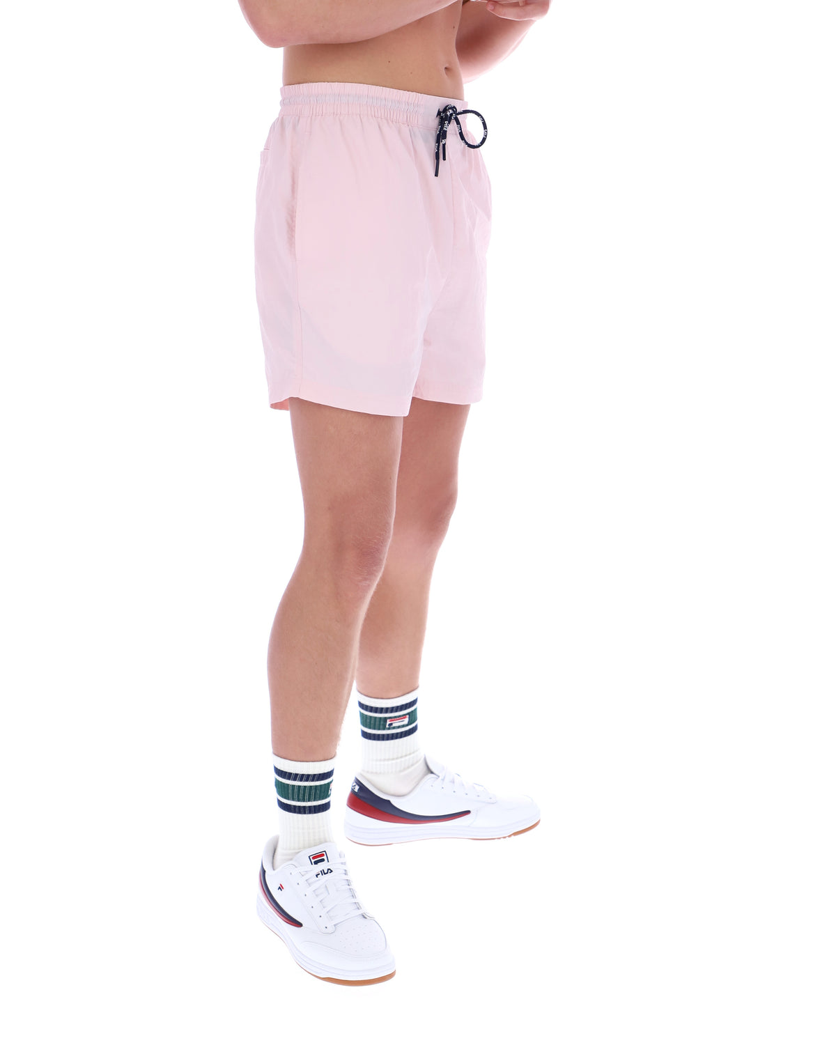 Person wearing light pink shorts on a white background