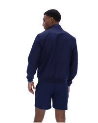 Displays a model wearing the Navy 'Fila' branded Arturo Coach Jacket