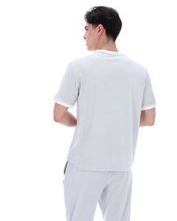 Person wearing a plain dawn blue t-shirt and pants on a white background