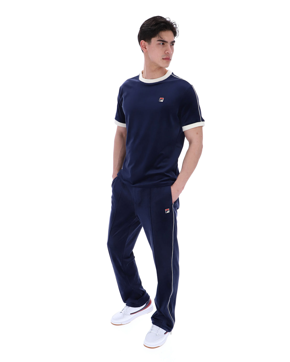 Person wearing a navy tracksuit with a brand logo on a white background