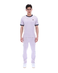 Person wearing a lilac t-shirt with a FILA logo, paired with matching joggers, on a white background