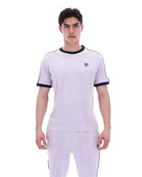 Person wearing a lilac t-shirt with a FILA logo on a white background