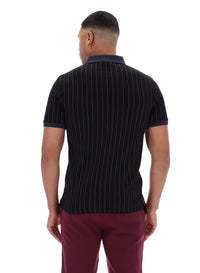 Man wearing a black pinstripe polo shirt and maroon pants on a white background