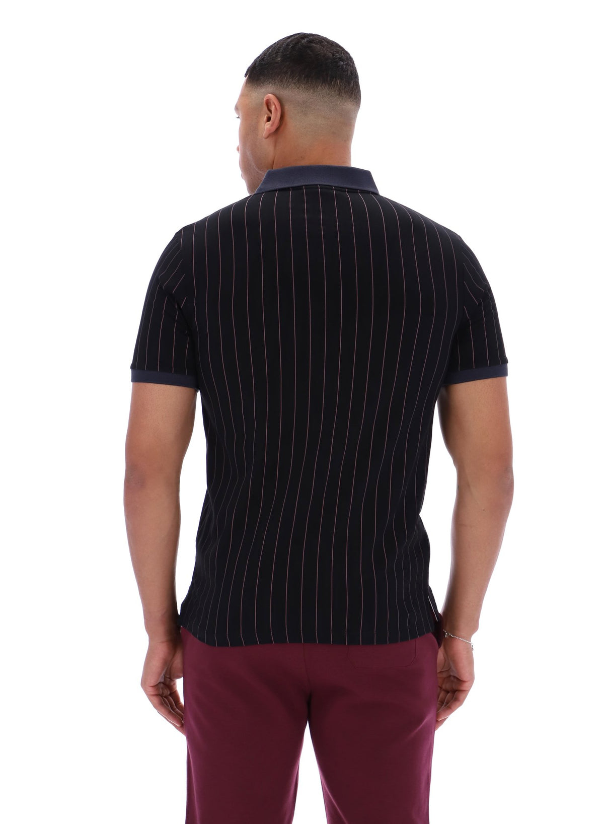Man wearing a black pinstripe polo shirt and maroon pants on a white background