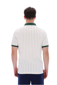 A man viewed from behind wearing a short-sleeve polo shirt with thin vertical dark pinstripes on an off-white base, featuring a dark green collar and sleeve trim, paired with navy blue pants against a plain white background.
