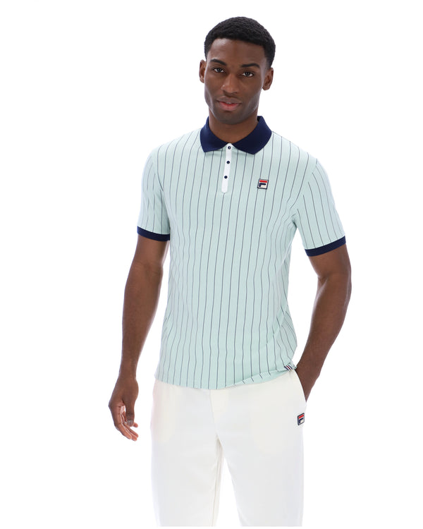 Man wearing a light blue striped polo shirt with dark collar and trim on a white background