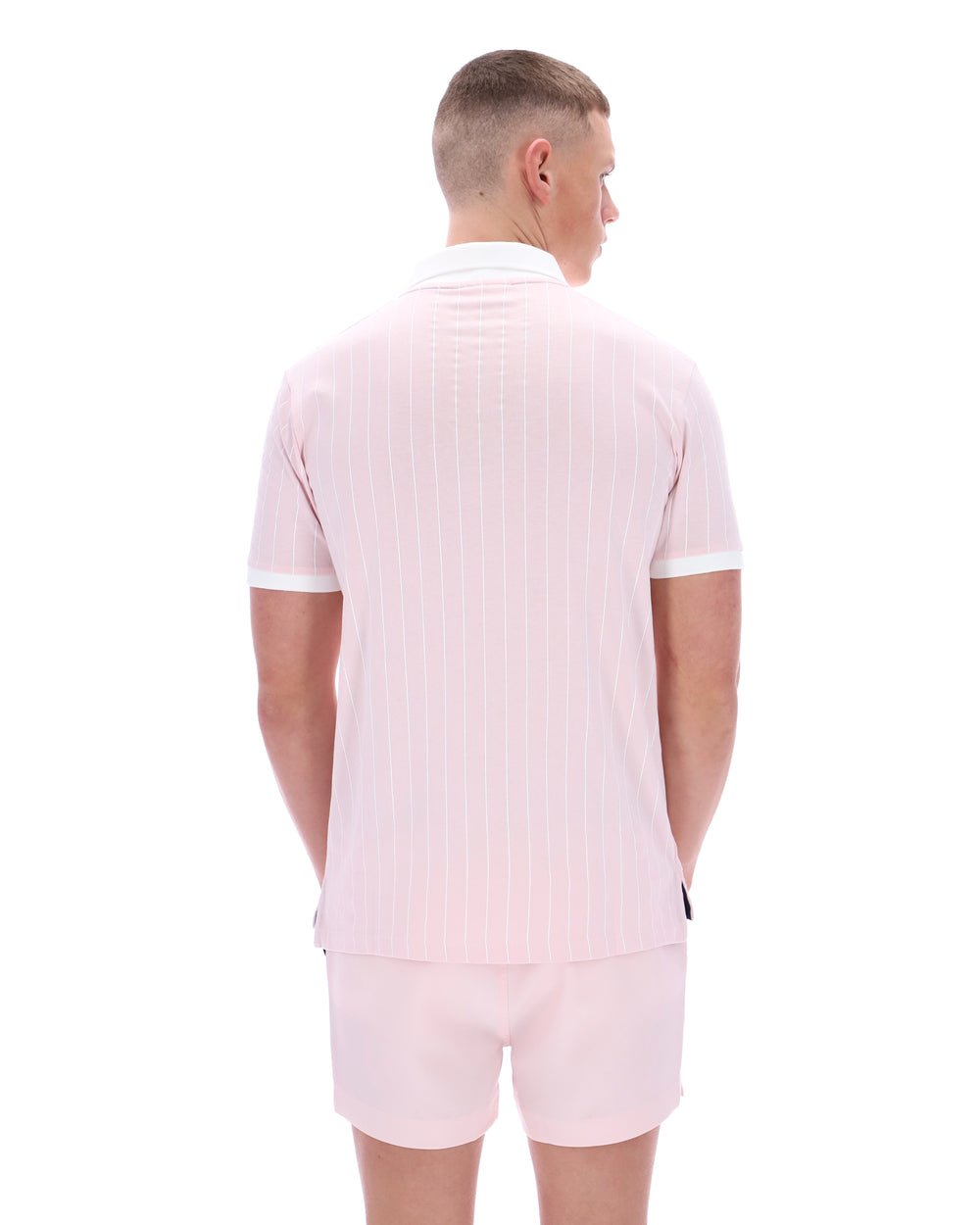 Man wearing a light pink outfit with a white background