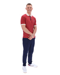 Man wearing a red striped polo shirt and blue pants on a white background