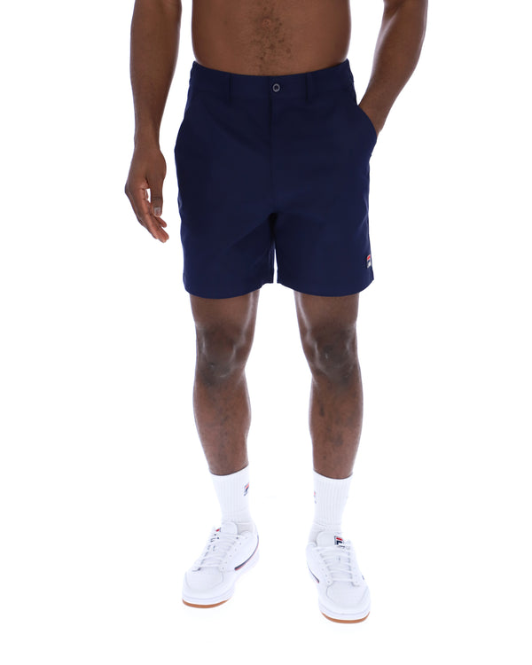 Displays a model wearing the Navy 'Fila' Caruso Chino Shorts