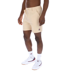 Displays a model wearing the Classic Beige 'FILA' branded Caruso Chino Shorts