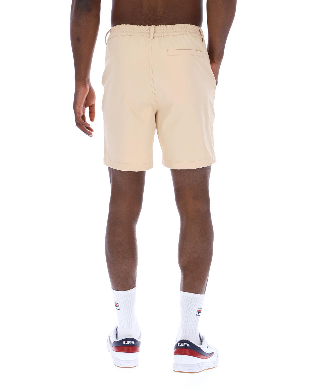 Displays a model wearing the Classic Beige 'FILA' branded Caruso Chino Shorts