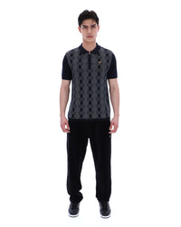Man wearing a black and grey patterned shirt with black pants on a white background