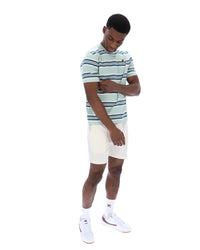 Man wearing a striped polo shirt and white shorts on a white background