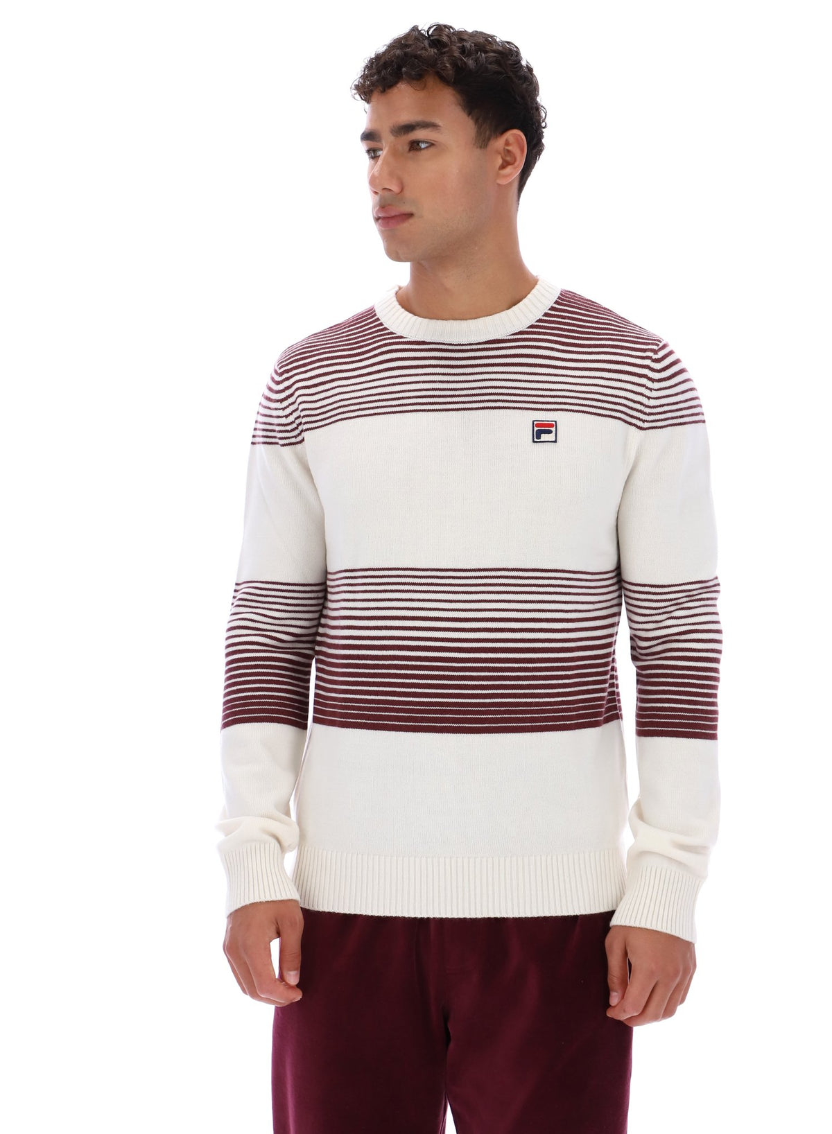 Man wearing a striped sweater with a visible brand logo on a white background