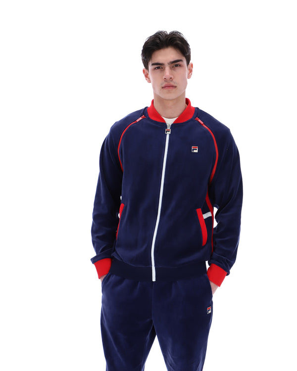 Person wearing a navy tracksuit with red accents on a white background