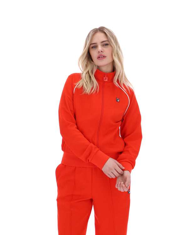 Woman wearing a bright orange tracksuit on a white background