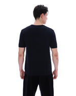 Person wearing a black t-shirt and pants on a white background