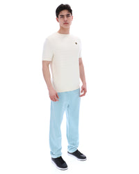 Man wearing a white t-shirt and light blue jeans on a white background