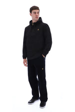 A man modeling a black pullover hoodie and matching black sweatpants with small gold embroidered logos, standing against a solid white background.