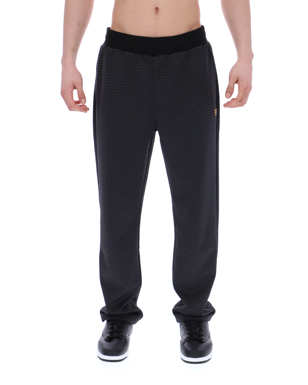 Black patterned jogger pants worn by a person on a white background