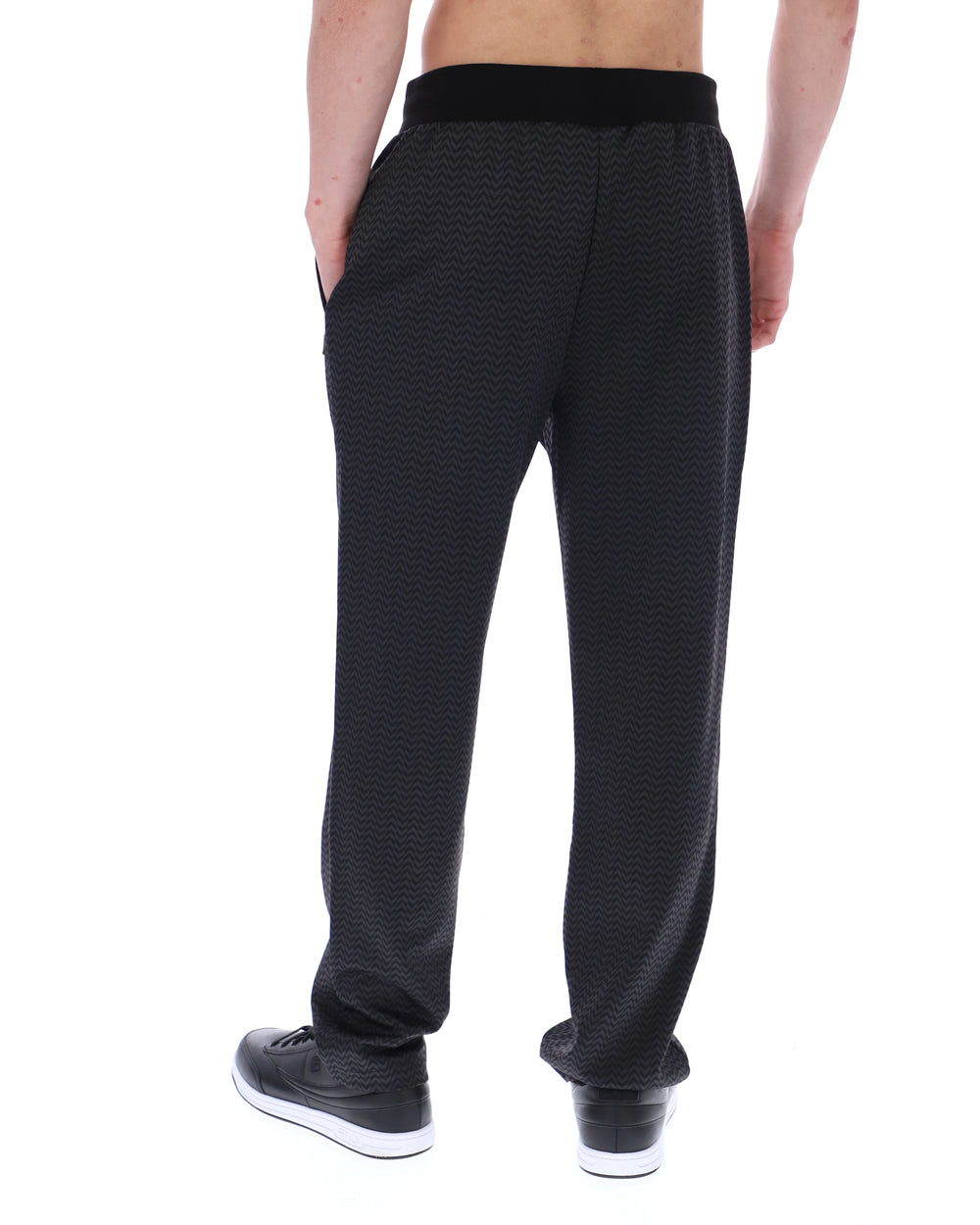 Black patterned jogger pants worn by a person on a white background