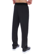 Black patterned pants worn by a person on a white background