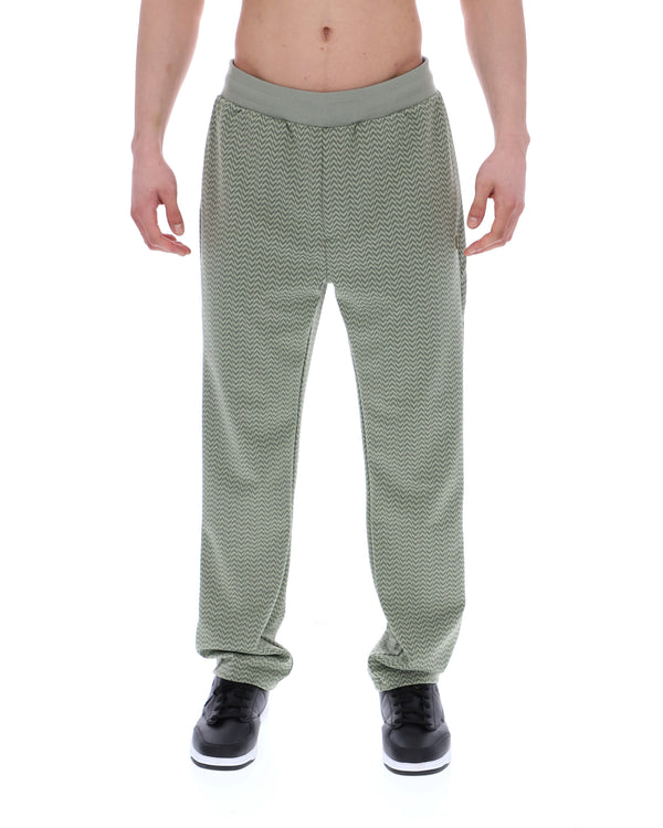 Displays a model wearing the Sea Foam 'FILA' branded Edward Herringbone Pant