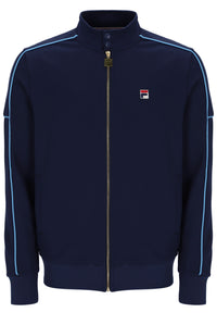 A navy blue Fila zip-up track jacket with light blue piping along the shoulders and sleeves, featuring a small Fila logo patch on the left chest.
