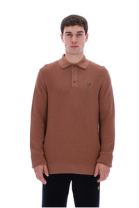 A man wearing a brown textured knit polo sweater with a small embroidered logo on the chest, paired with black pants, against a plain white background.