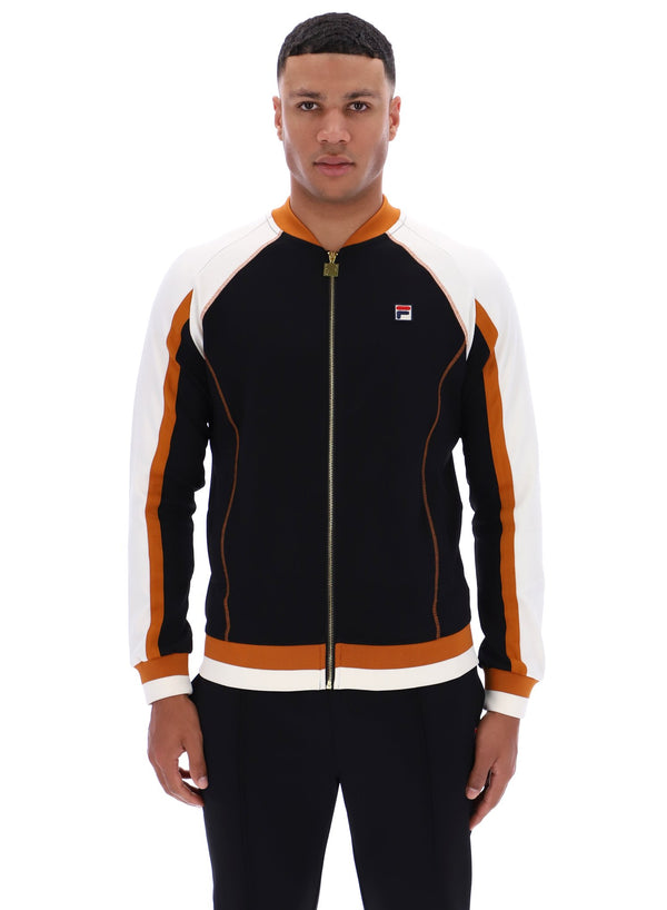 Man wearing a black and orange tracksuit with a visible FILA logo on a white background