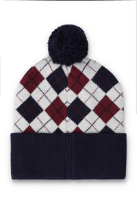 A knit pom-pom beanie hat featuring an argyle pattern in white, navy, and burgundy, with a solid navy ribbed cuff and pom-pom.
