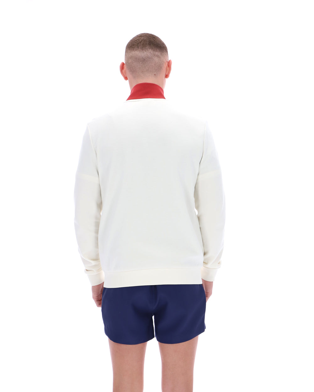 Person wearing a white sweater and blue shorts on a white background